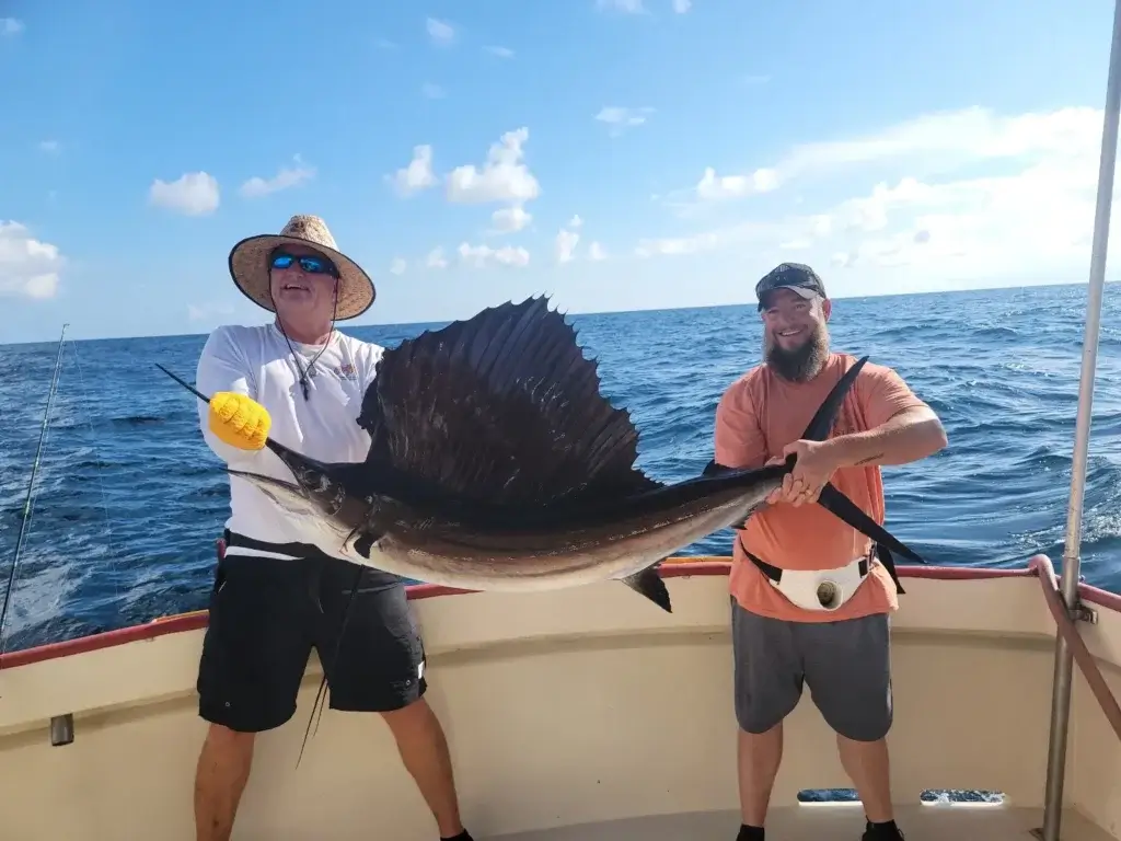 Anglers proudly holding a massive sailfish caught on an unforgettable trolling fishing trip in Panama City Beach with Captain Mike Charters.